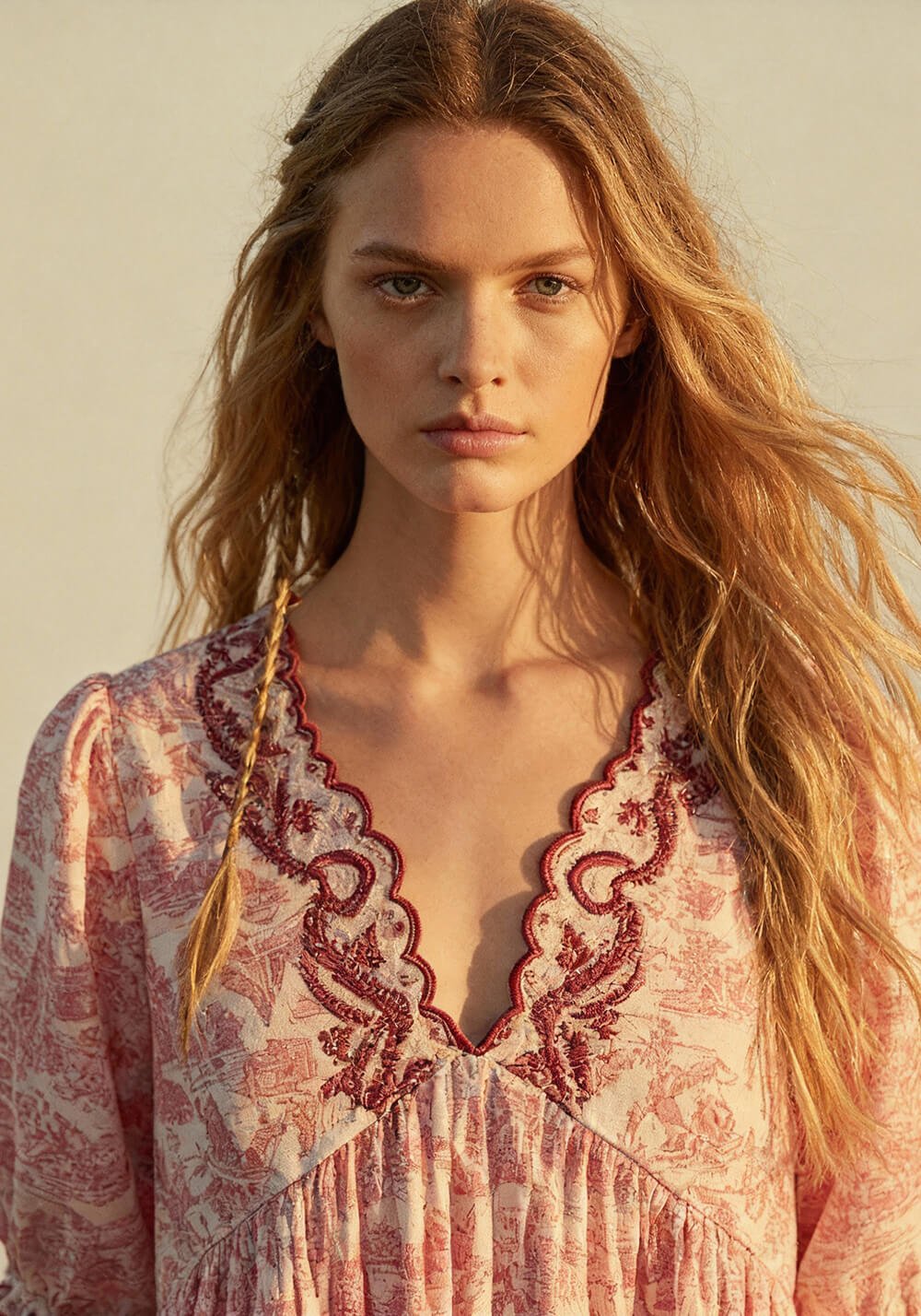 Donna con abito cipria ricamato in luce dorata