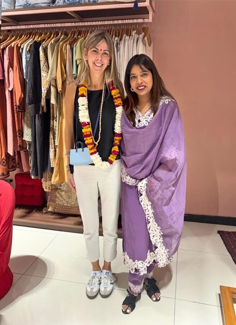 Due donne in boutique di abbigliamento con capi esposti